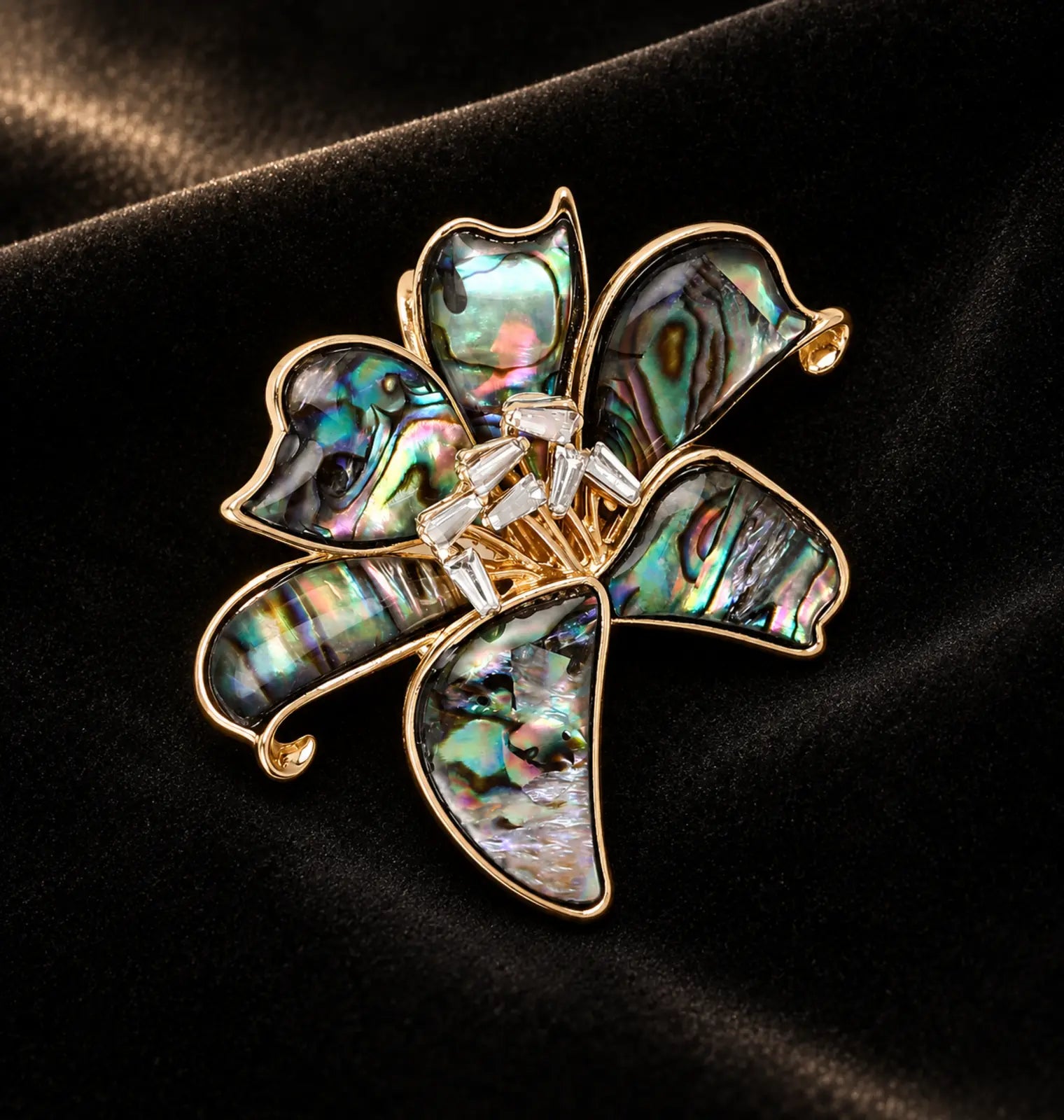 Sculptural floral brooch on ivory and black studio surfaces